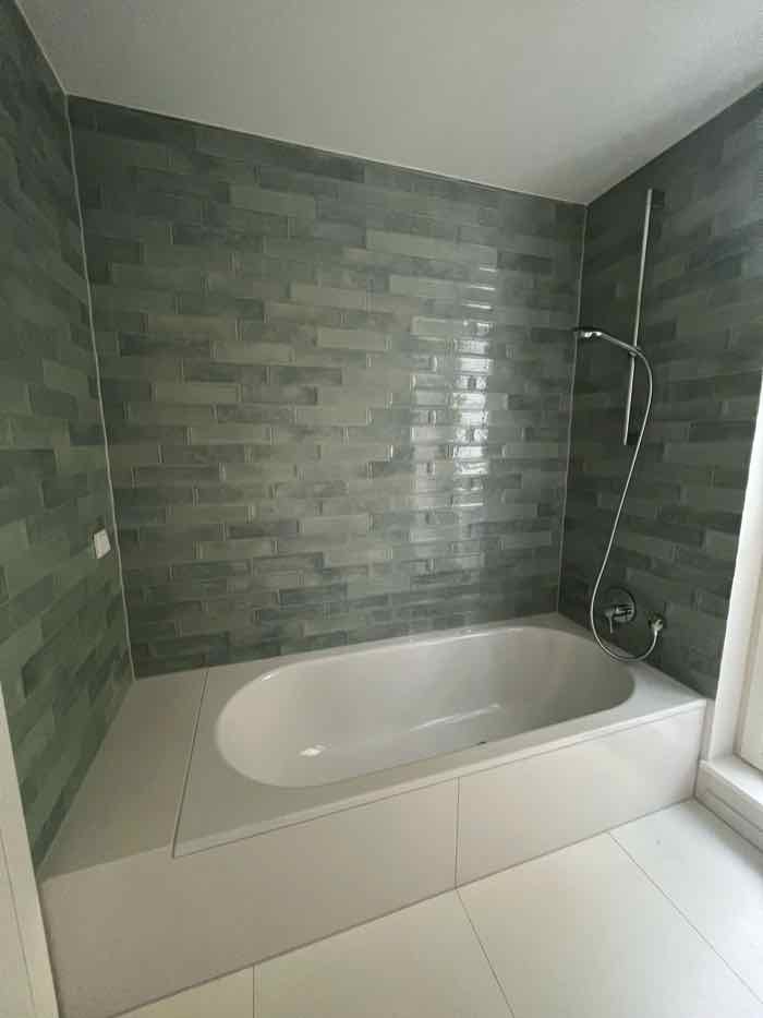 Badezimmerwand mit großformatigen Fliesen und schmaler Fuge